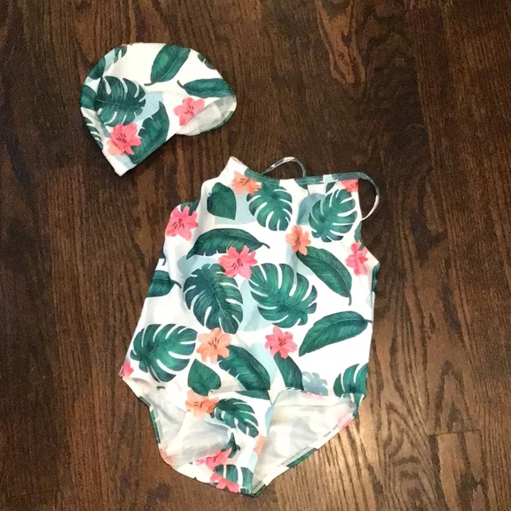 Shein - tropical floral print kids' swimsuit accompanied by a matching swim cap.